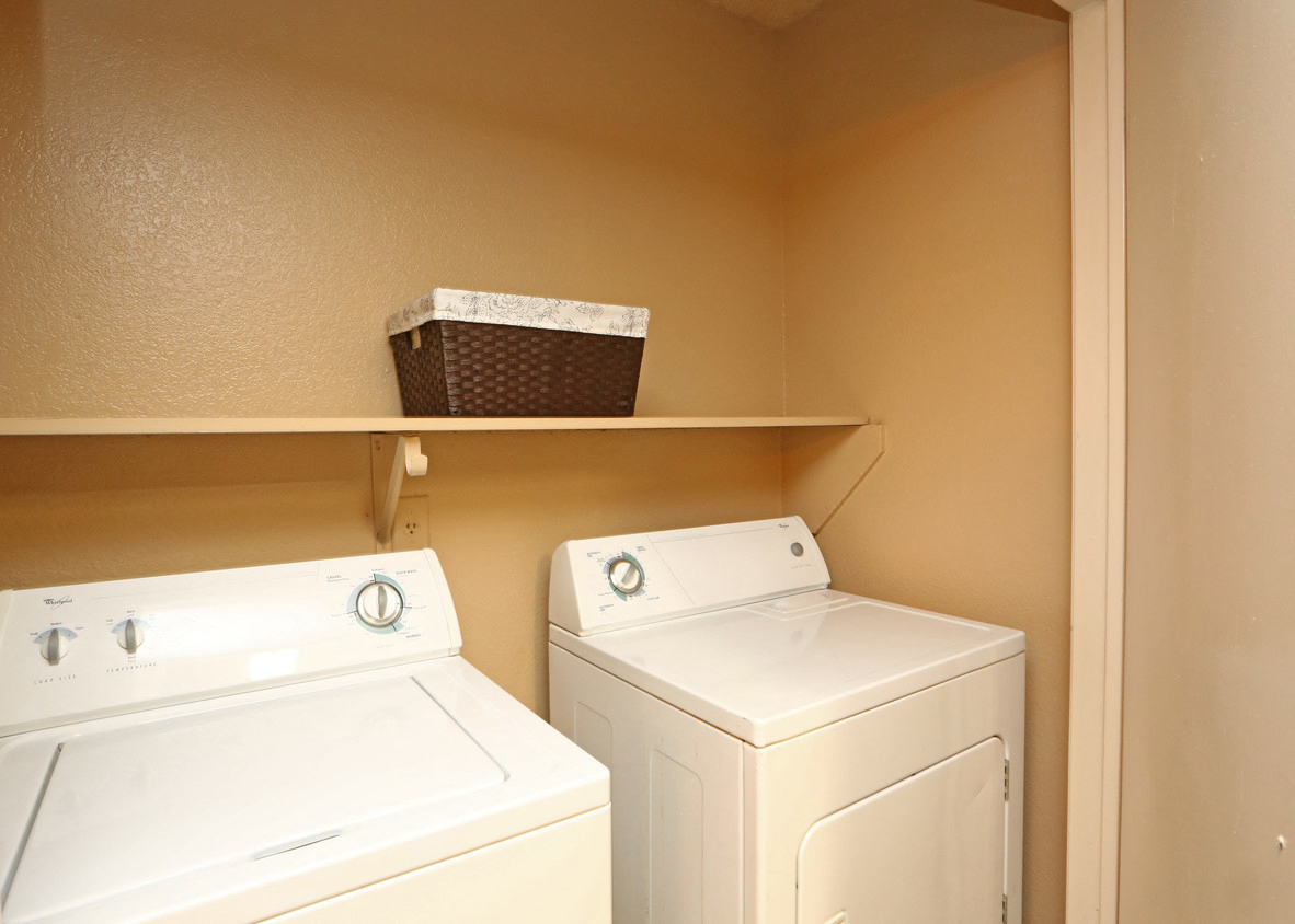 a washer and dryer in a laundry room with shelves