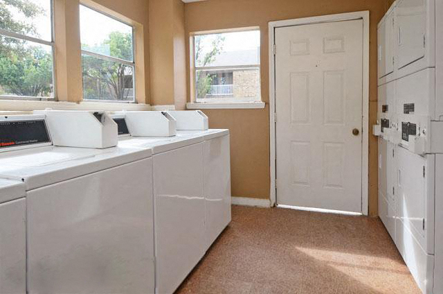 a laundry room with two washing machines and a white door