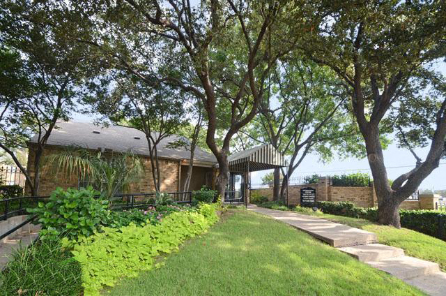 a house with a lawn and trees in front of it