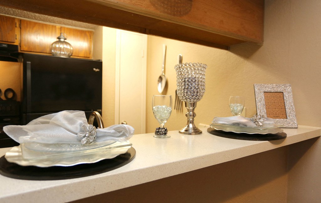 a kitchen counter with plates and glasses on it