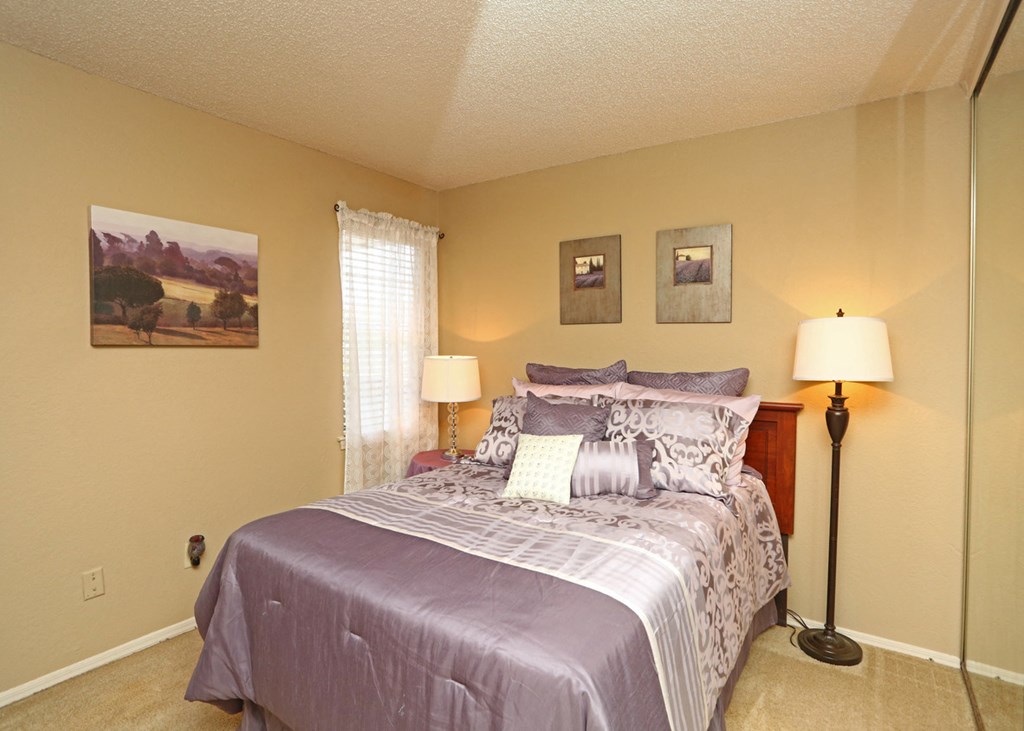 a bedroom with a bed and two lamps