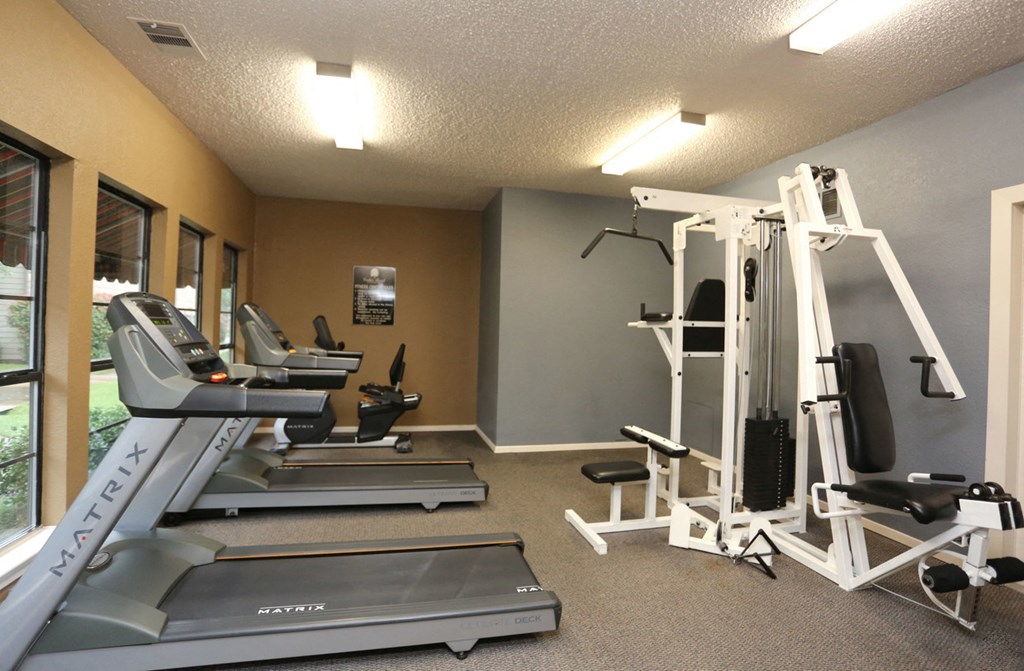 a gym with a lot of machines and weights