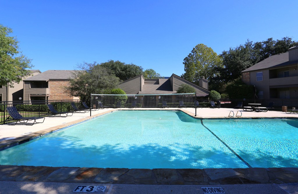 the view of a swimming pool with an apartment building in the background