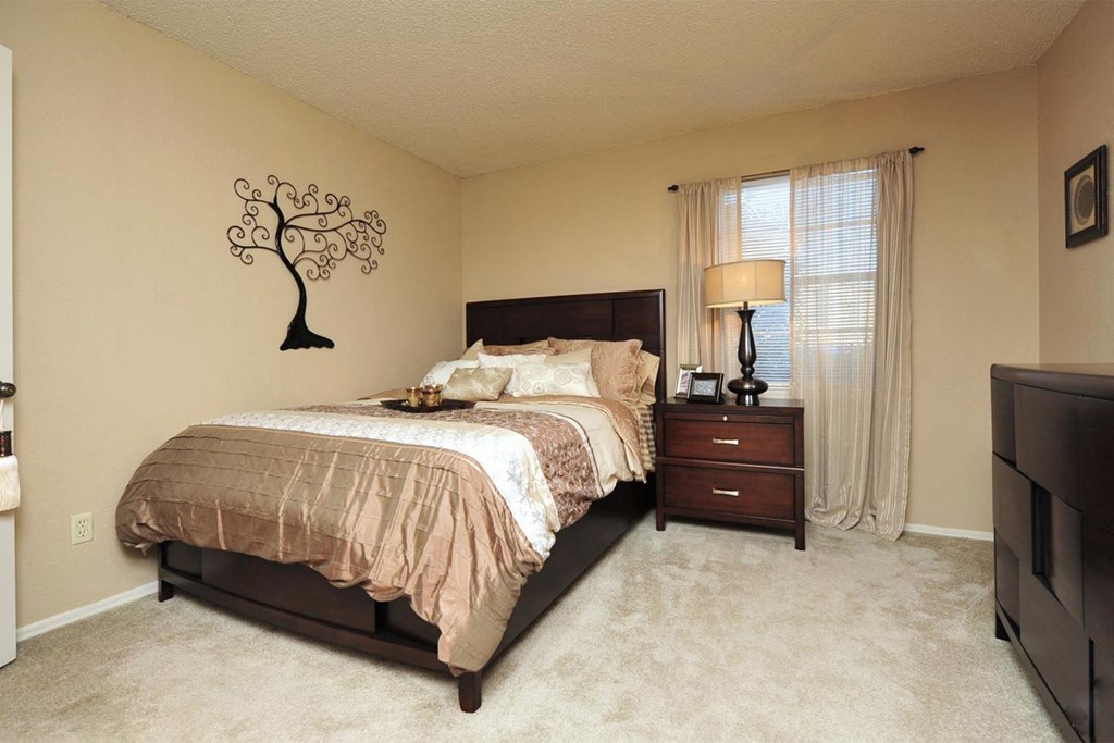 a bedroom with a bed and a tree on the wall