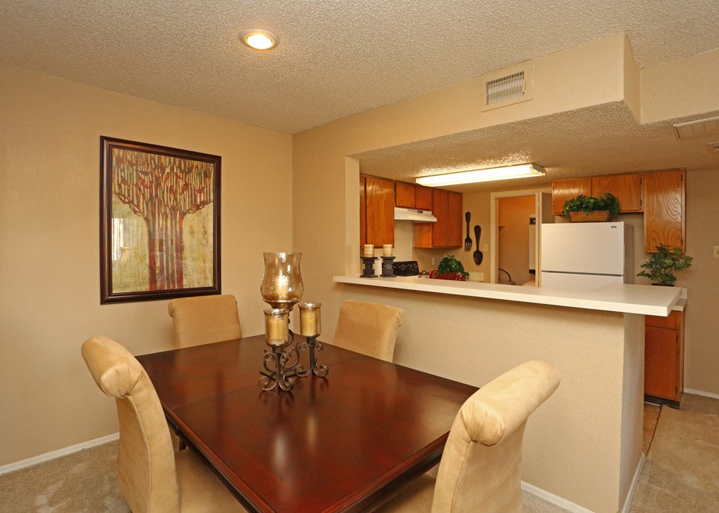 a dining room with a table and chairs and a kitchen
