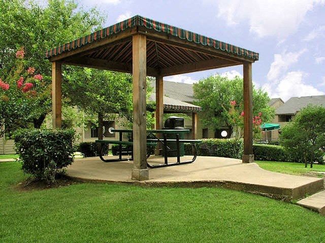 a gazebo with a picnic table in a yard