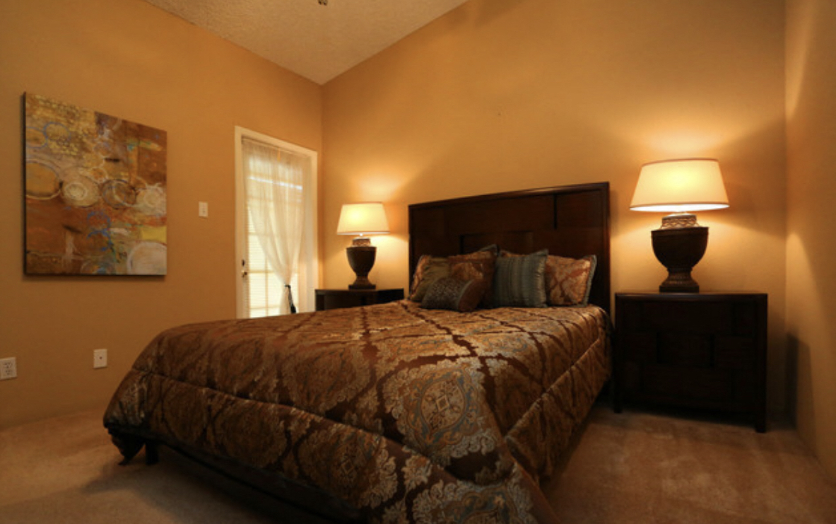 a bedroom with a large bed and two lamps