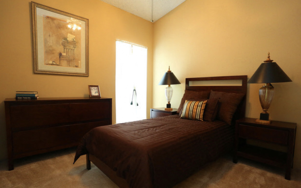 a bedroom with a bed and a dresser and a window