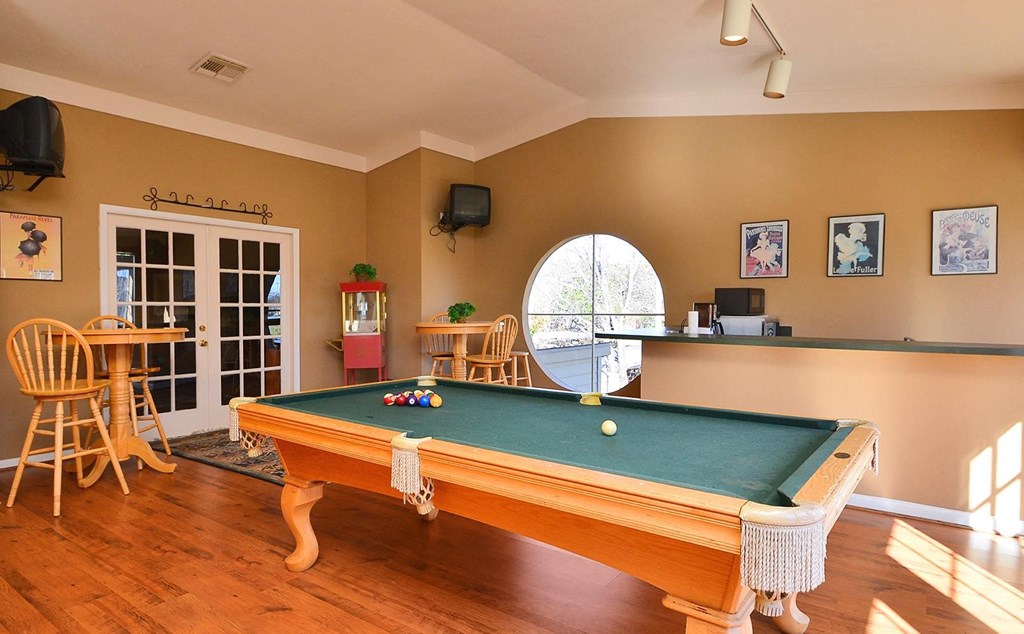 a game room with a pool table and a bar