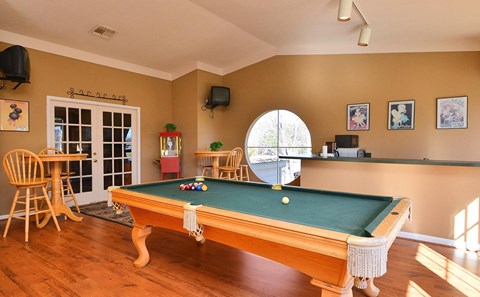 a game room with a pool table and a bar