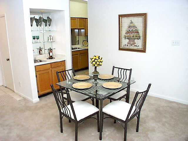 a dining room table with four chairs  and a kitchen
