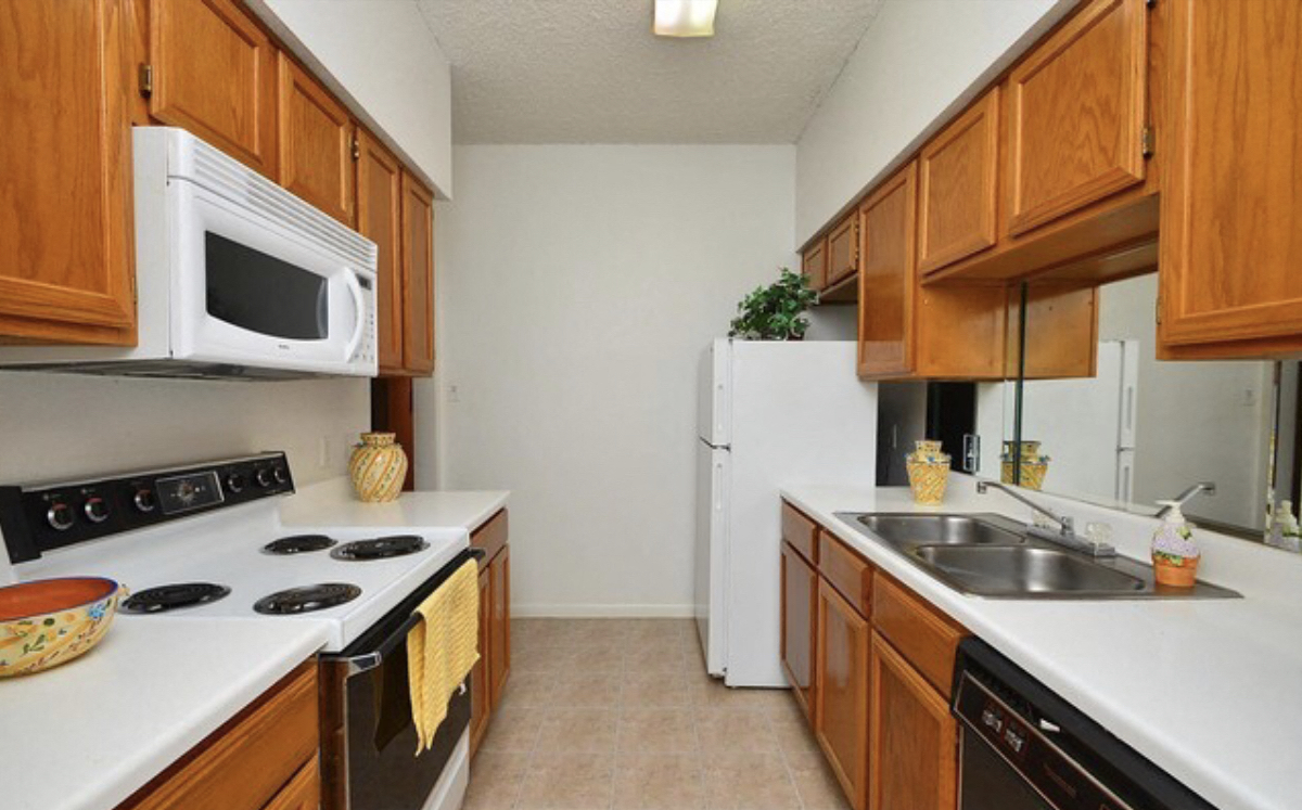 a kitchen with wooden cabinets and white appliances and a sink