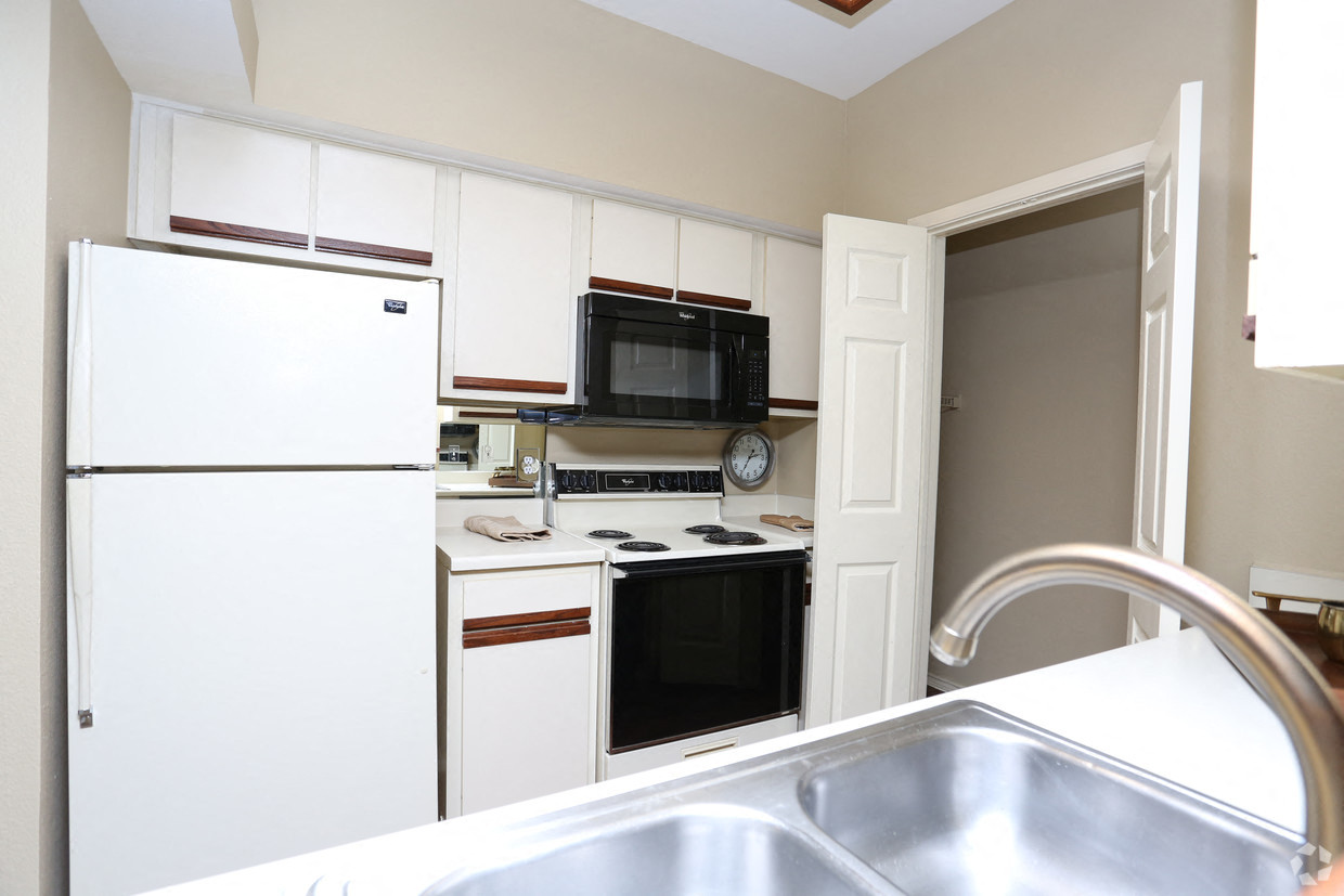 a kitchen with white cabinets and black appliances and a sink