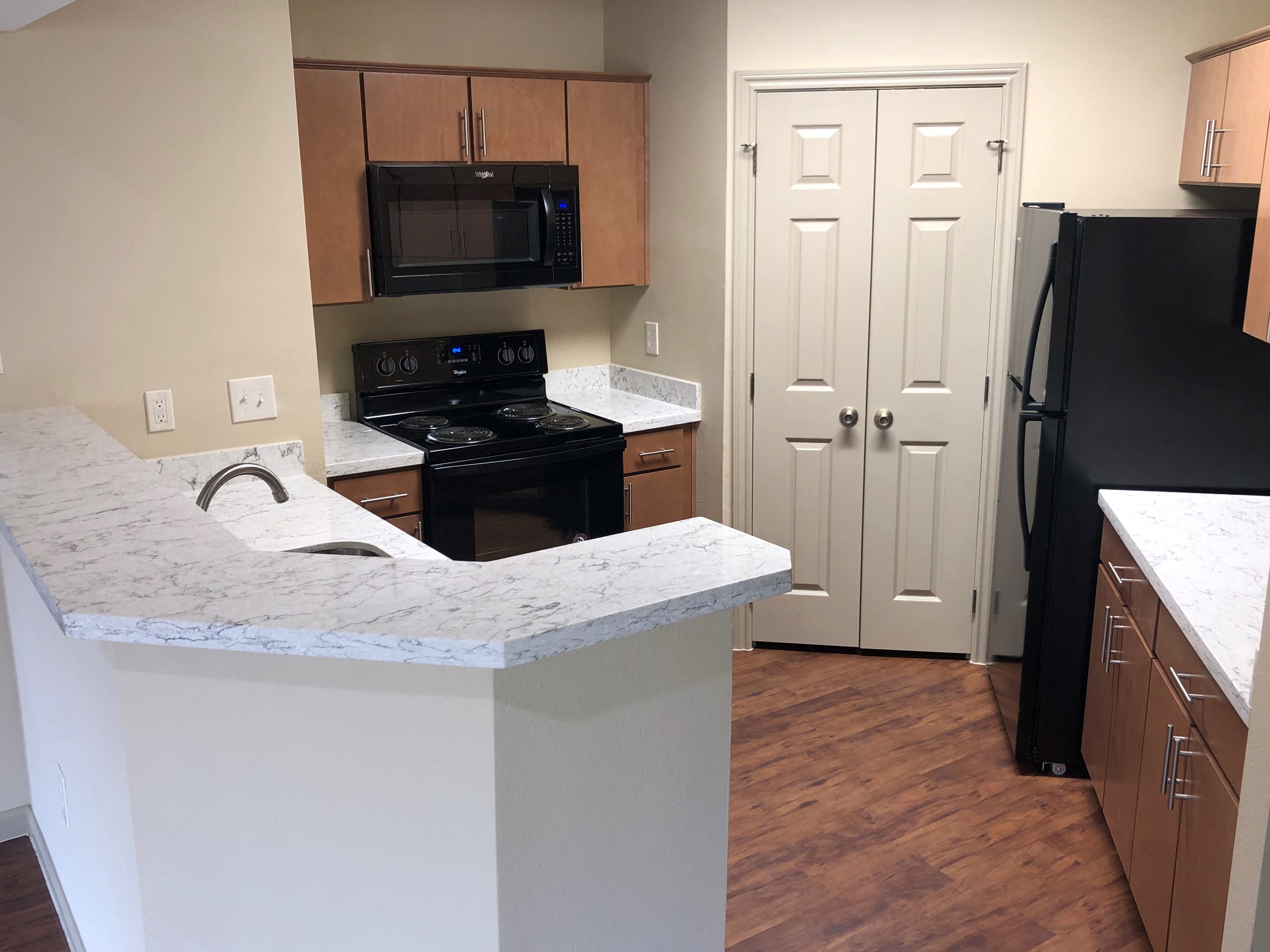 a kitchen with a counter and a refrigerator and a door