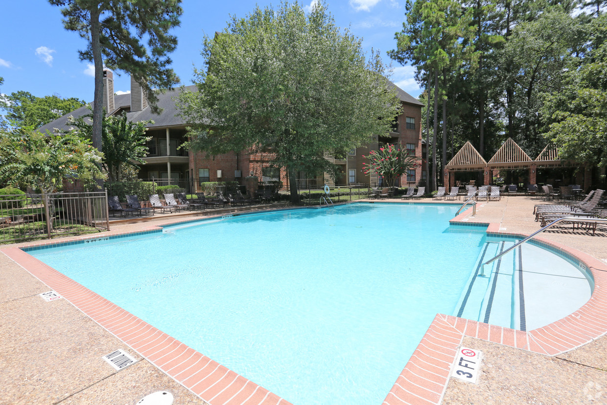 a swimming pool with trees and a building in the background