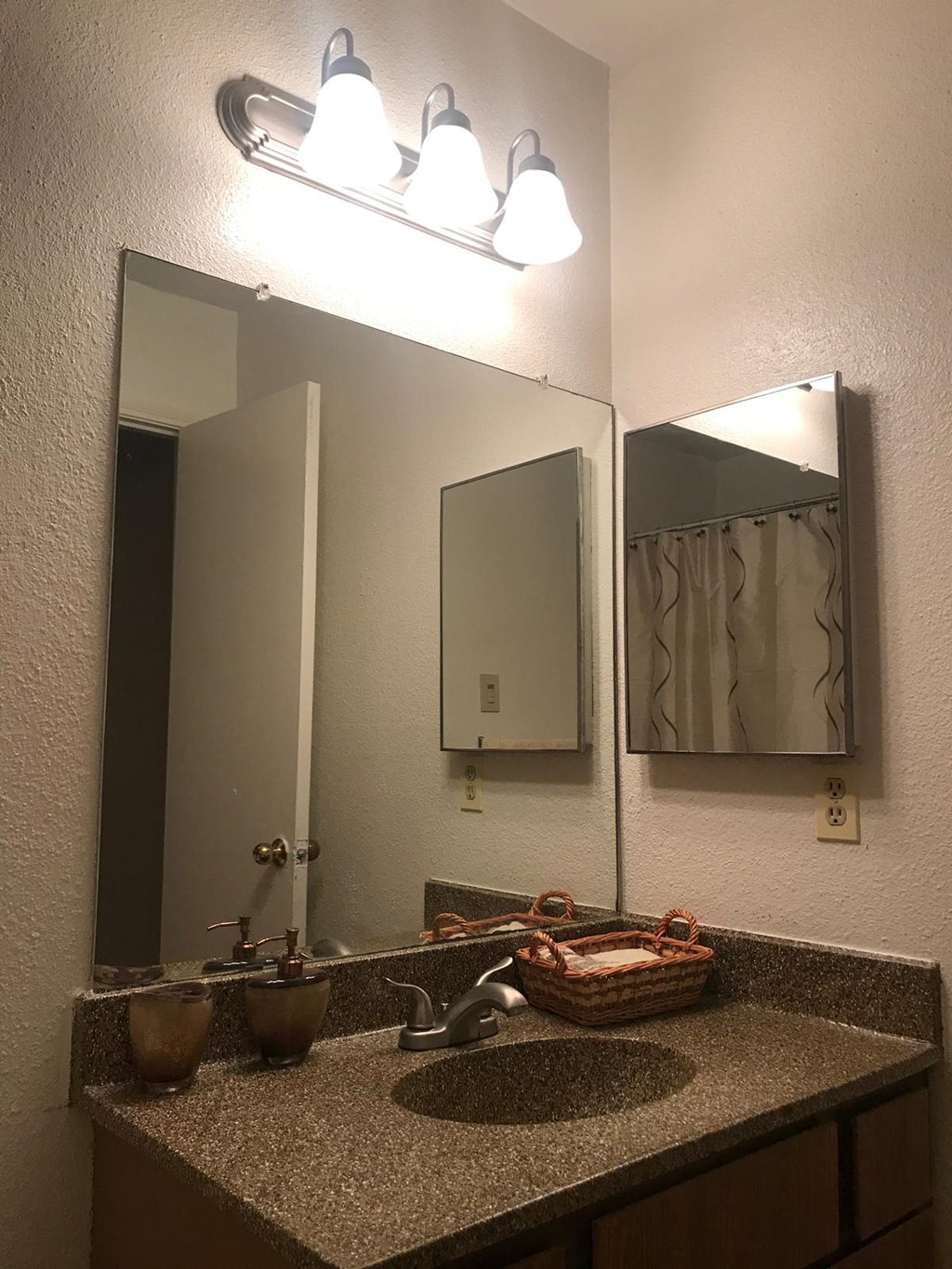 a bathroom with a sink and two mirrors