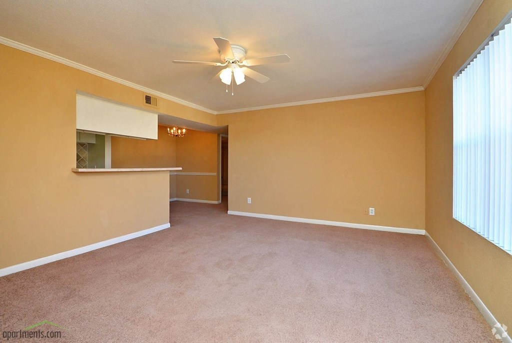 an empty living room with a ceiling fan