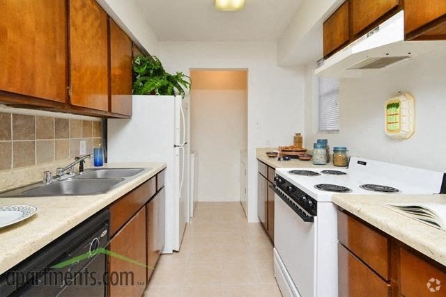 a kitchen with white appliances and wooden cabinets