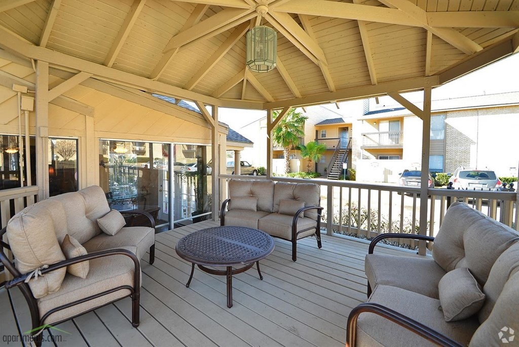 a covered porch with couches and chairs and a table