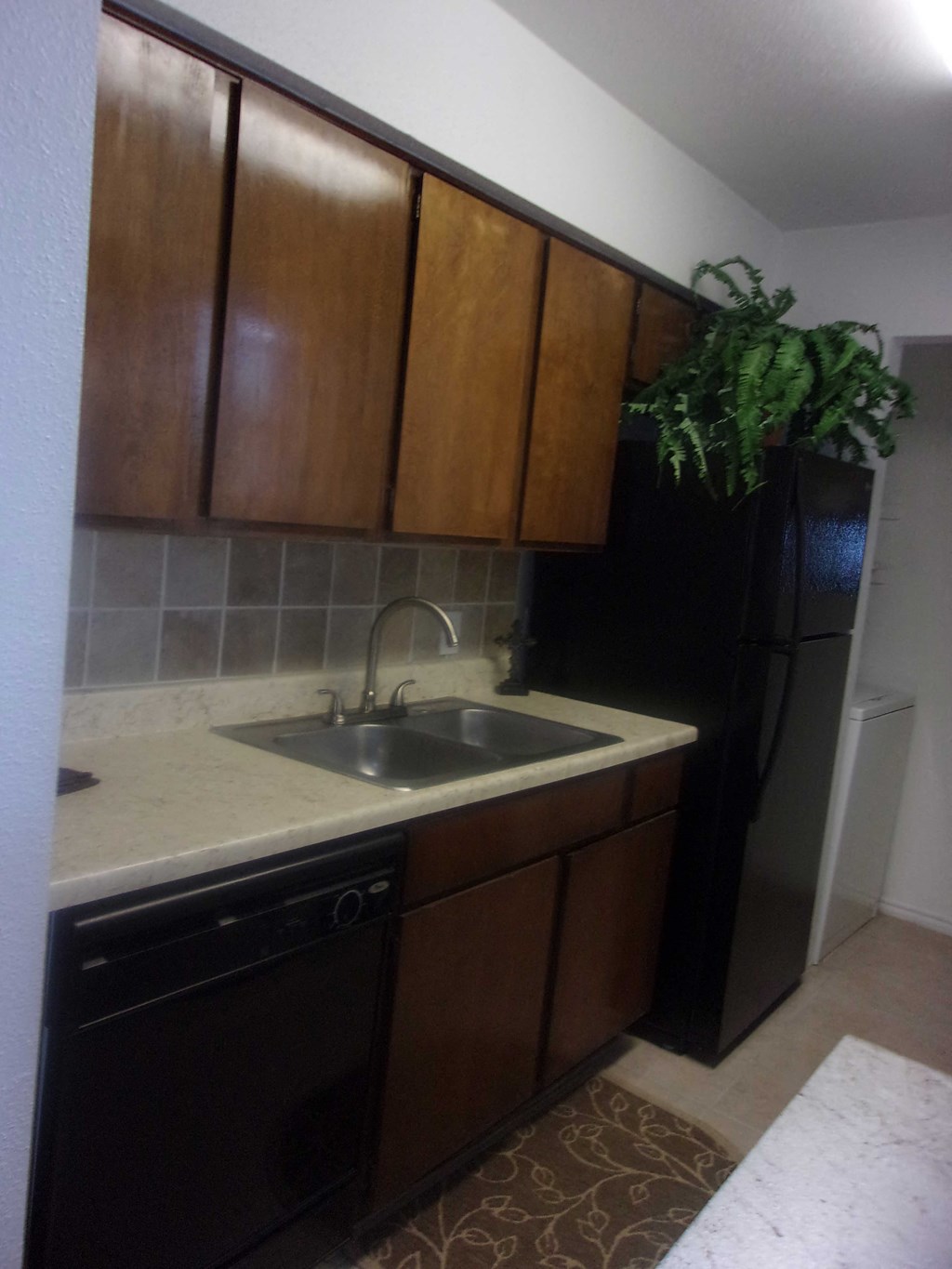 an empty kitchen with a sink and a refrigerator