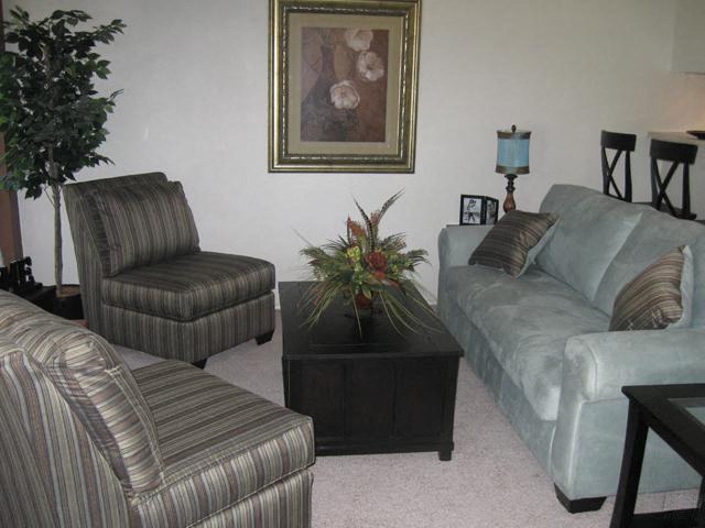 a living room with couches and chairs and a table