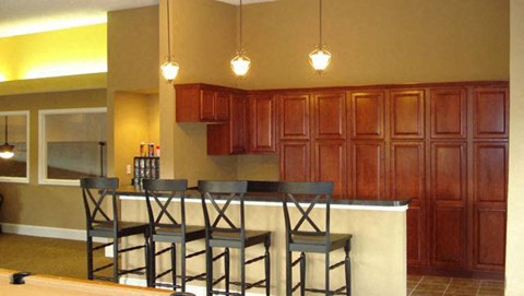 a kitchen with a bar with four chairs