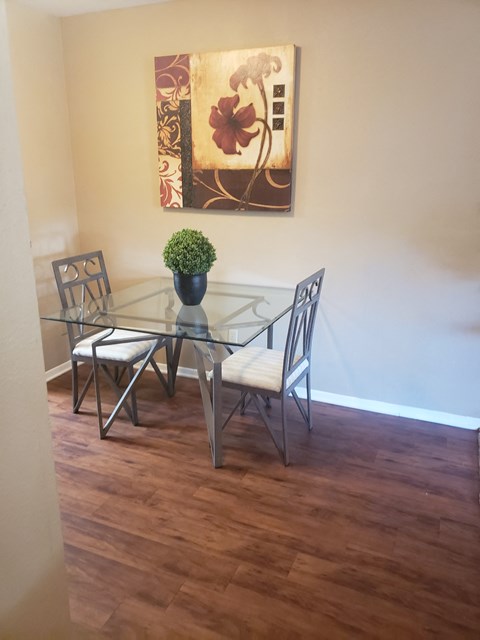 a dining room with a glass table and chairs