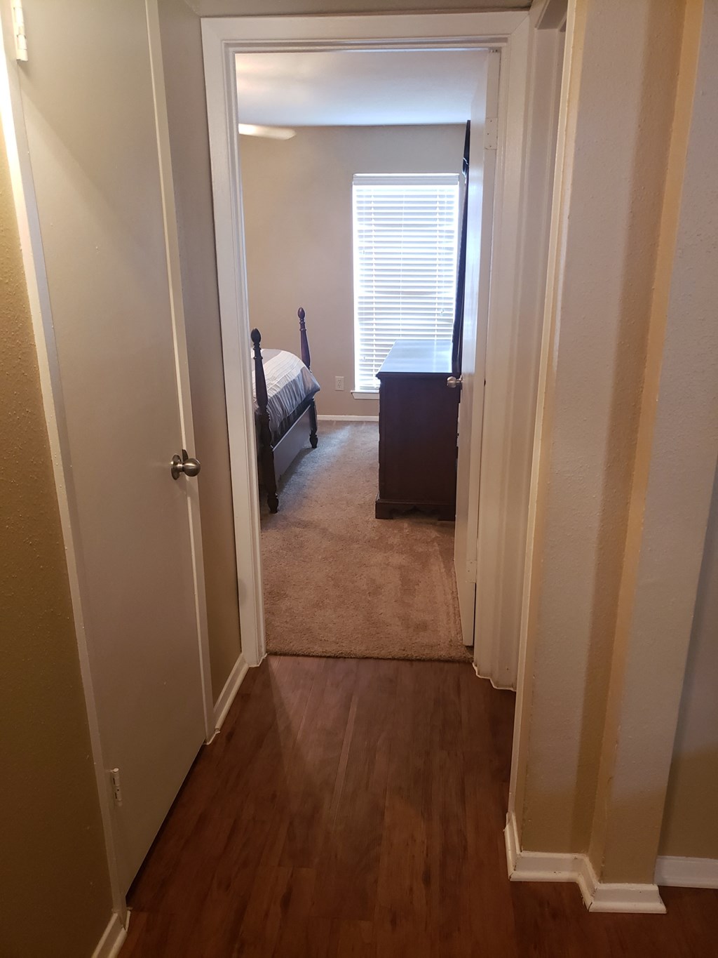 a bedroom with a door open to a room with a bed