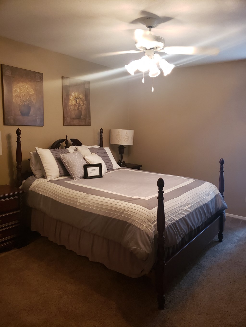 the master bedroom has a large bed and a ceiling fan