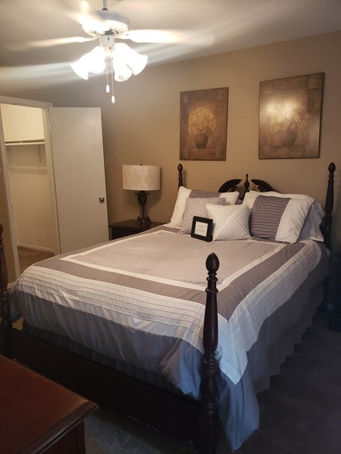 the master bedroom has a queen sized bed and a closet