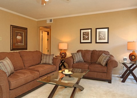a living room with two couches and a glass table