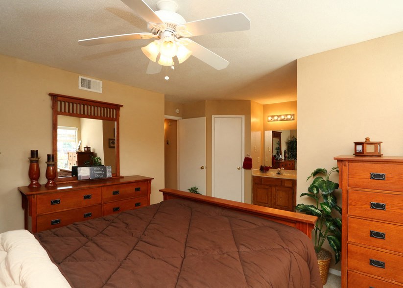 a bedroom with a large bed and a ceiling fan