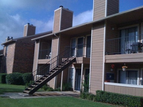 an apartment building with stairs and a balcony