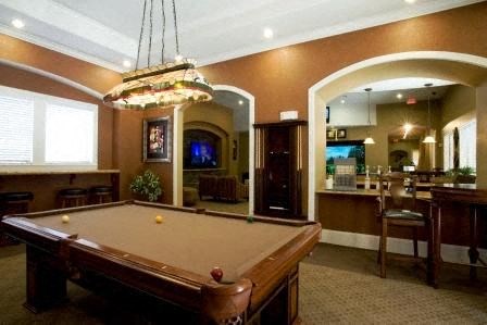 a living room with a pool table and a bar
