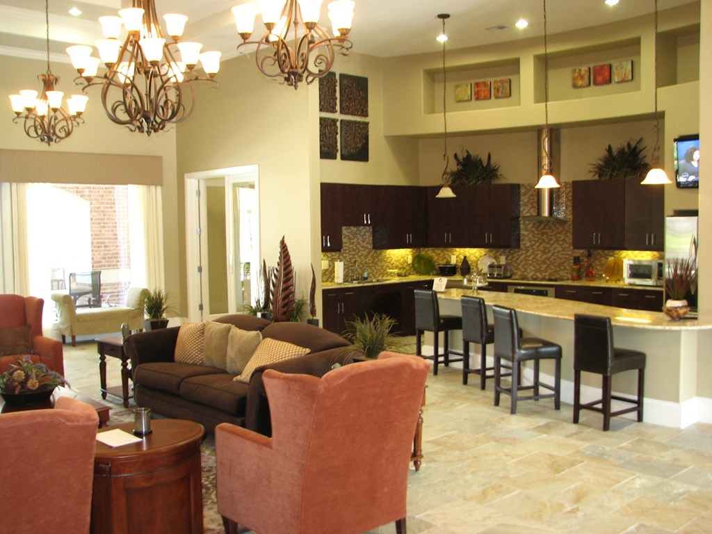 a living room and kitchen with a bar and couches