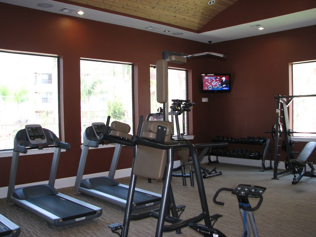 a gym with exercise equipment and a tv