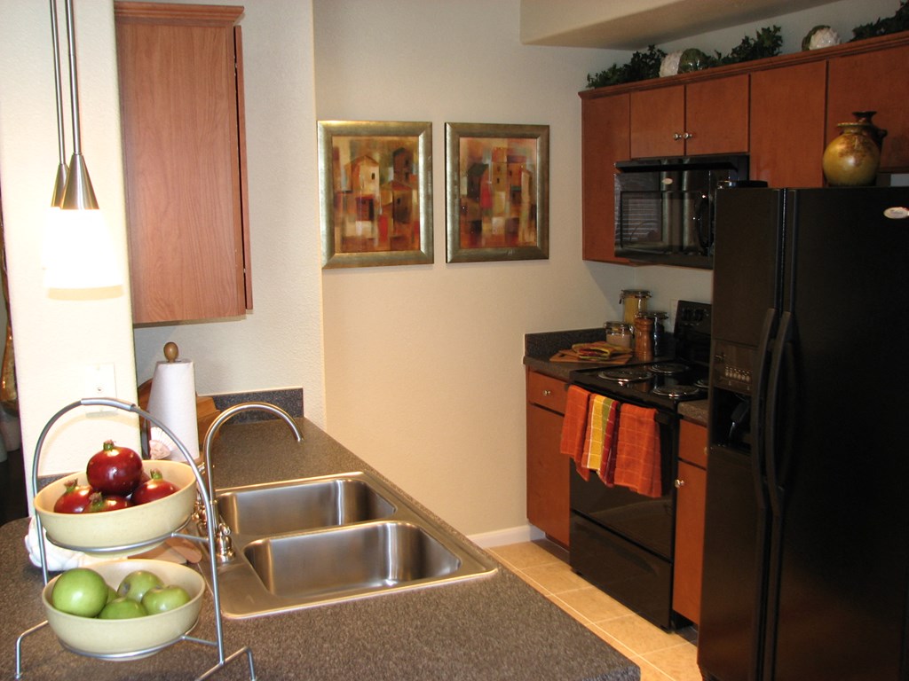 a kitchen with black appliances and a stainless steel sink
