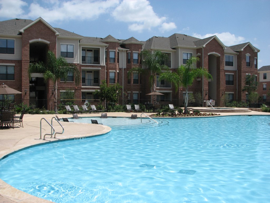a swimming pool with an apartment building in the background