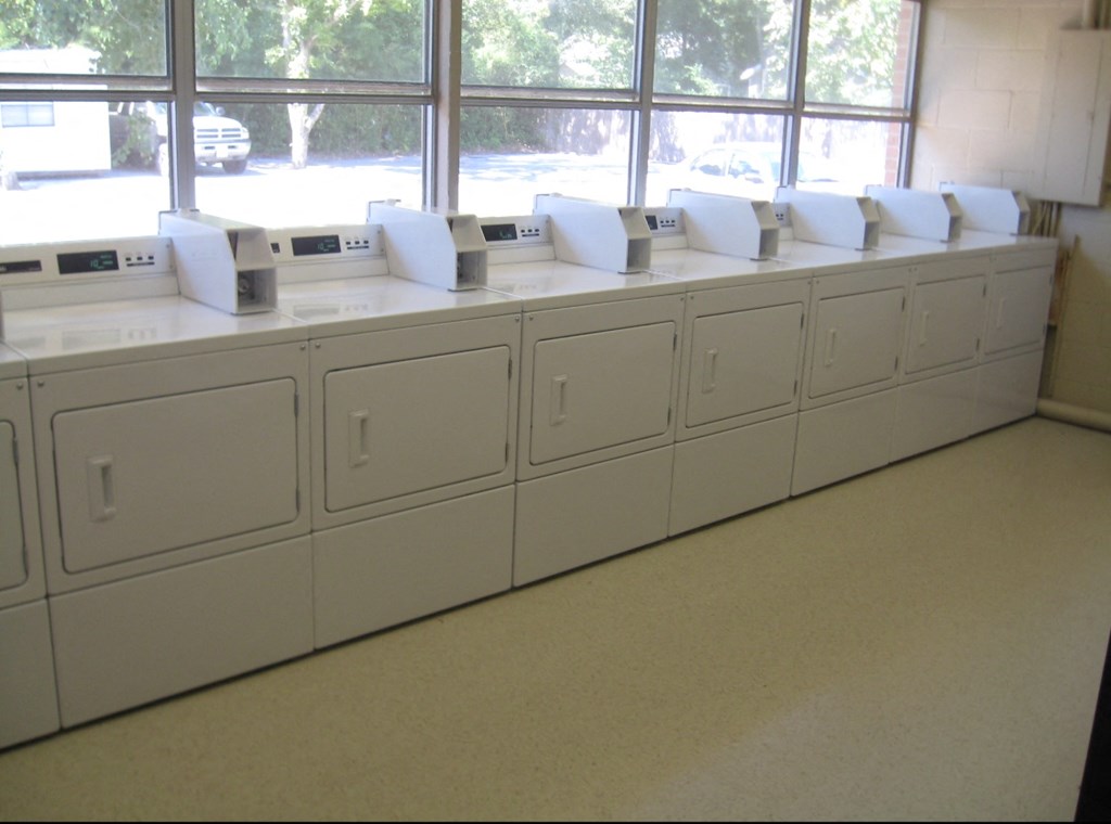 a row of white cabinets with rolls of toilet paper on them