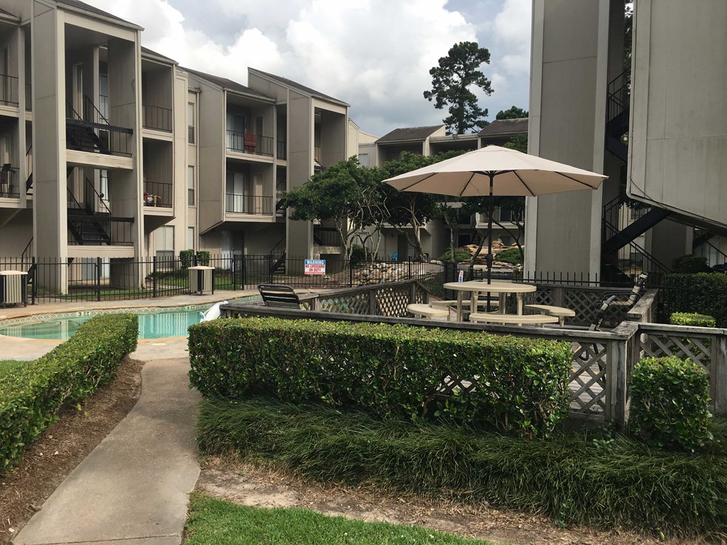 a view of an apartment building with a pool and patio