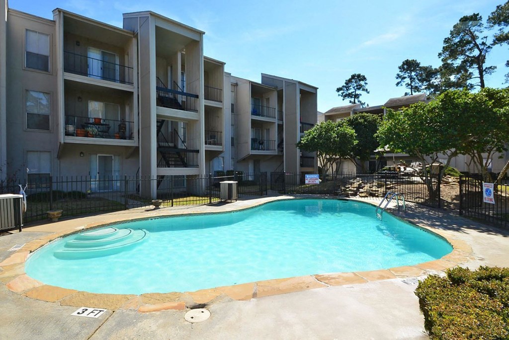 a large swimming pool in front of an apartment building