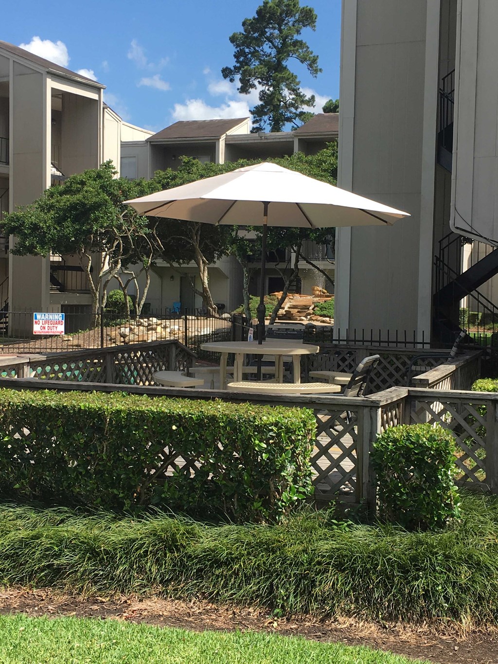 a patio with an umbrella in front of a building
