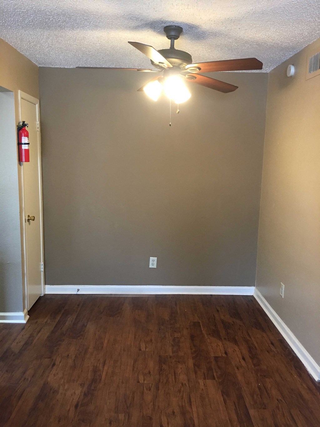 a living room with wood floors and a ceiling fan