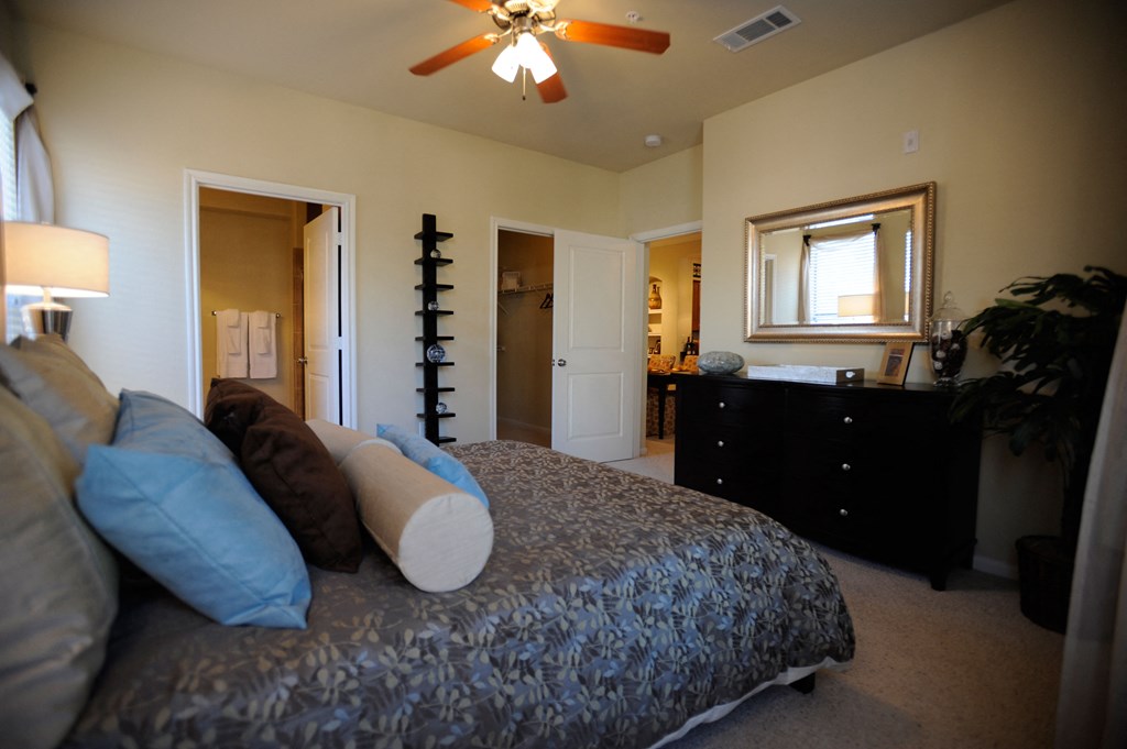 a bedroom with a large bed and a ceiling fan