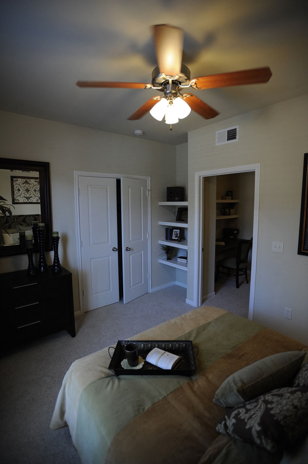 a bedroom with a ceiling fan and a bed