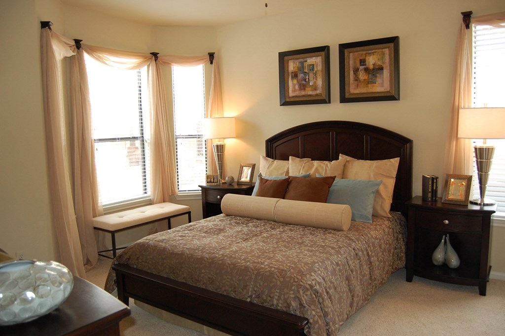 a bedroom with a bed and two windows