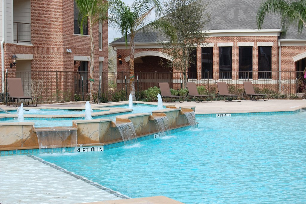 a swimming pool with a fountain in front of a building
