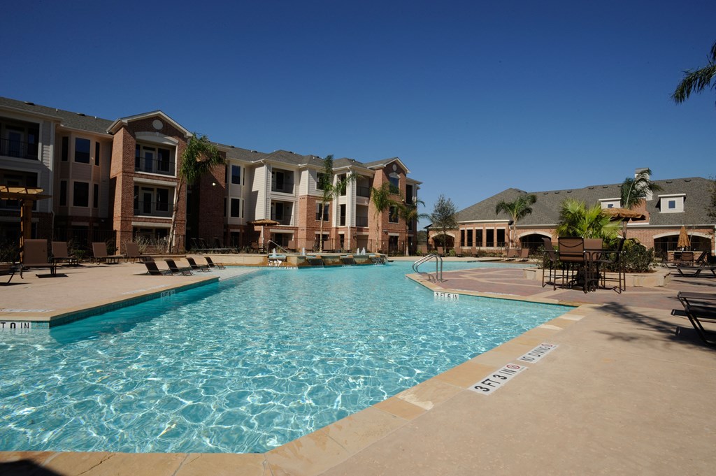 a swimming pool with an apartment building in the background
