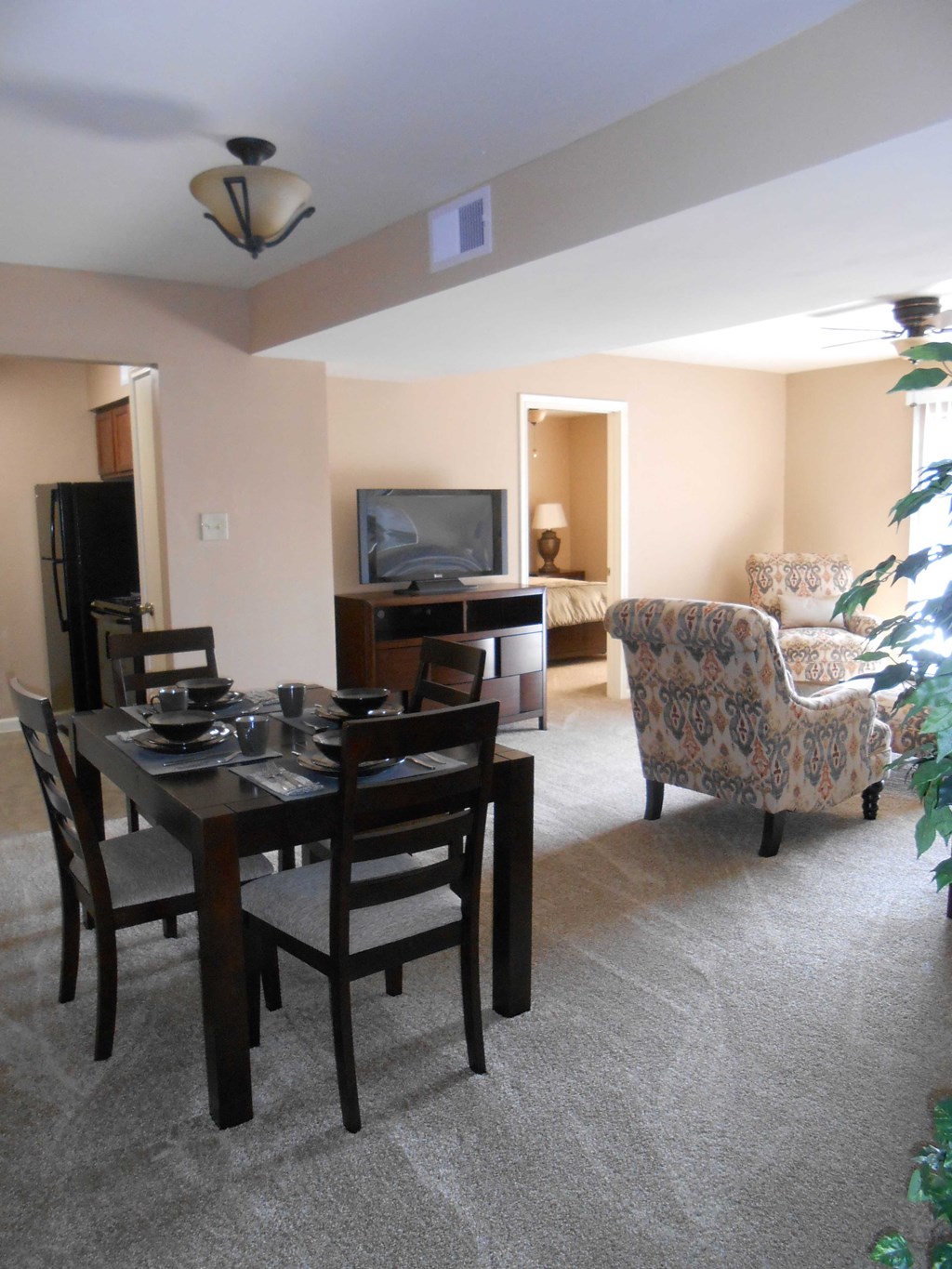 a living room and dining room with a table and chairs