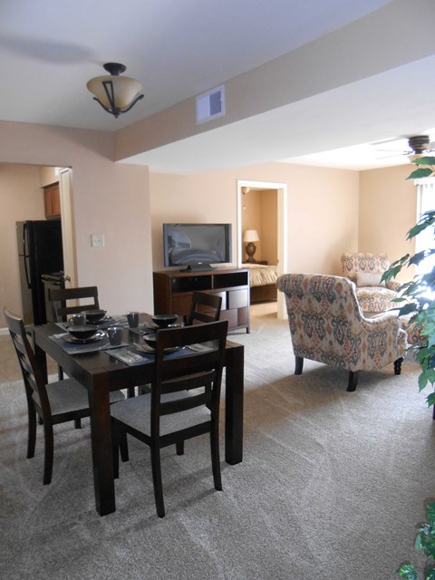 a living room and dining room with a table and chairs